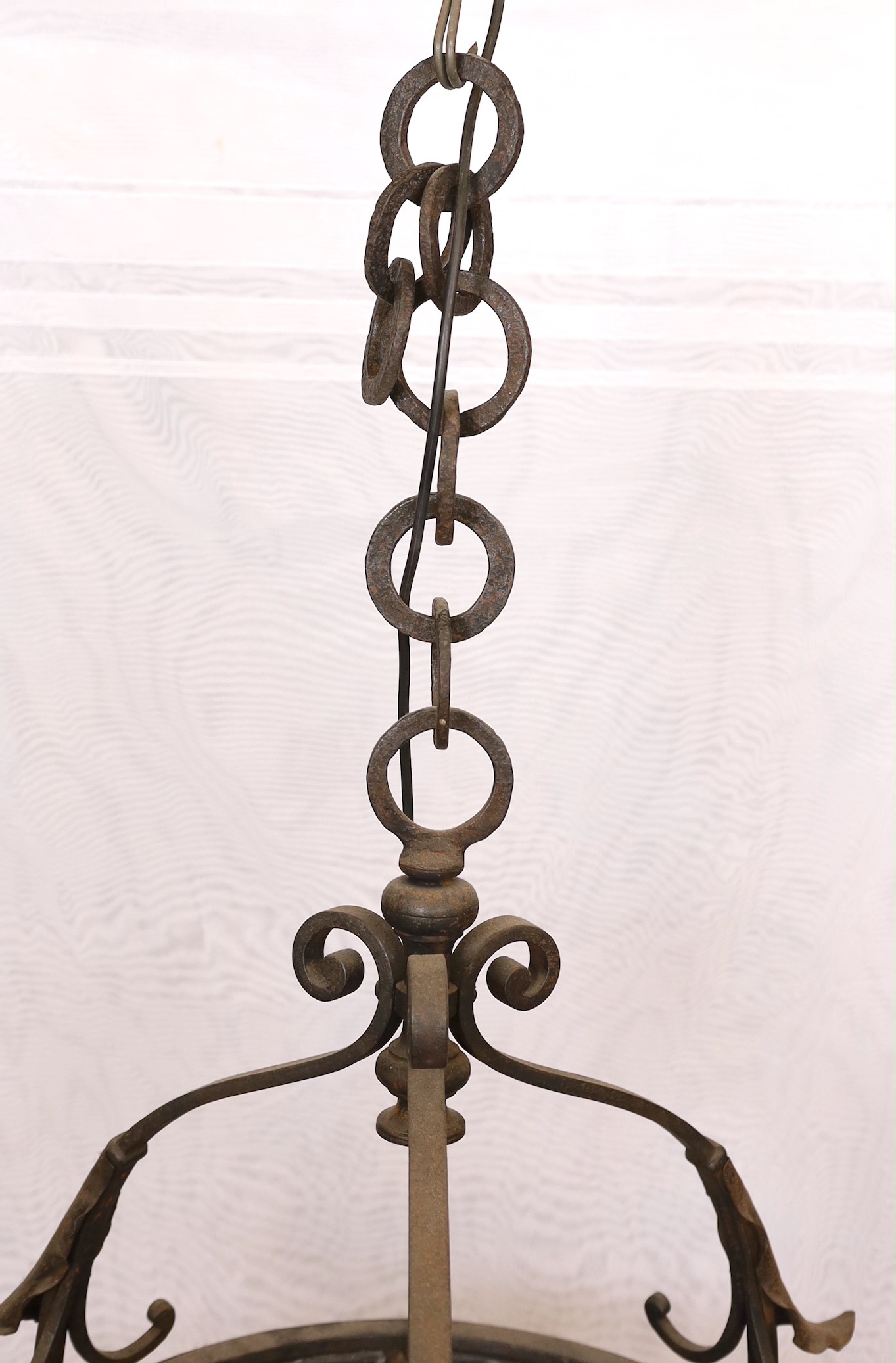An English Arts & Crafts wrought iron and stained glass basket shaped light fitting, height 70cm to the top of the fitting with additional 10 link heavy wrought iron chain. width 52cm.